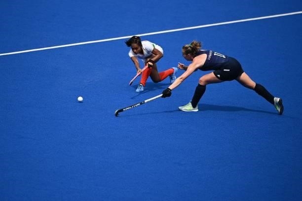 India's Sushila Chanu Pukhrambam strikes the ball past Ireland's Sarah Hawkshaw during their women's pool A match of the Tokyo 2020 Olympic Games...