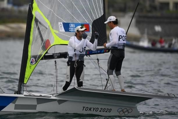 Portugal's José Costa and Jorge Lime celebrate after in the men's skiff 49er race during the Tokyo 2020 Olympic Games sailing competition at the...