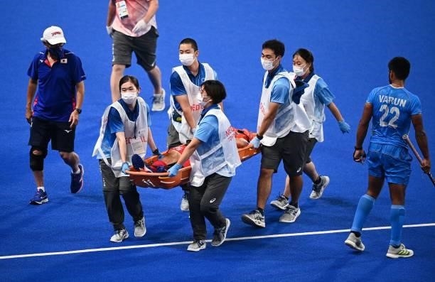 Japan's Shota Yamada is taken out of the pitch on a stretcher during the men's pool A match of the Tokyo 2020 Olympic Games field hockey competition...