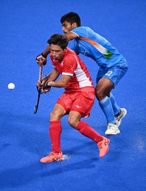 Apan's Kenta Tanaka and India's Varun Kumar vie for the ball during their men's pool A match of the Tokyo 2020 Olympic Games field hockey...
