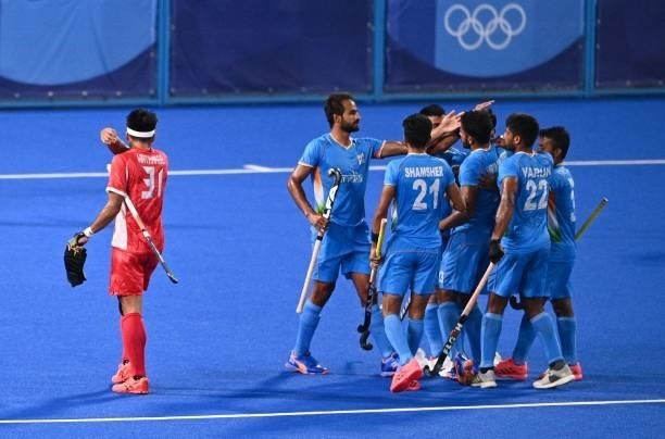 Players of India celebrate after scoring against Japan during their men's pool A match of the Tokyo 2020 Olympic Games field hockey competition, at...