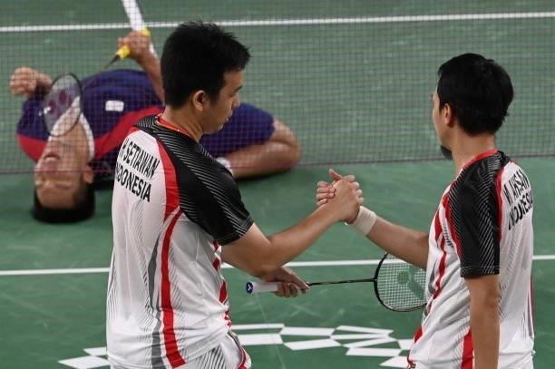 Indonesia's Mohammad Ahsan and Indonesia's Hendra Setiawan commiserate after losing their men's doubles badminton semi-final match as Taiwan's Lee...