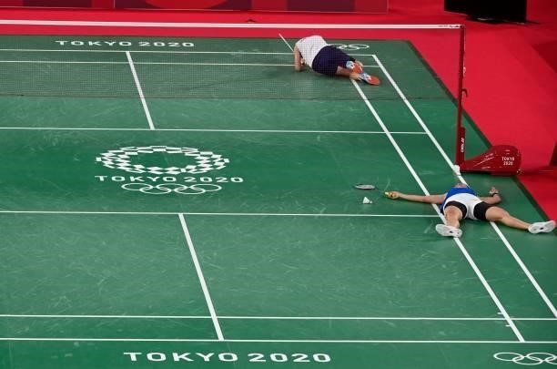 Taiwan's Tai Tzu-ying and Thailand's Ratchanok Intanon both fall at the end of a rally in their women's singles badminton quarter final match during...