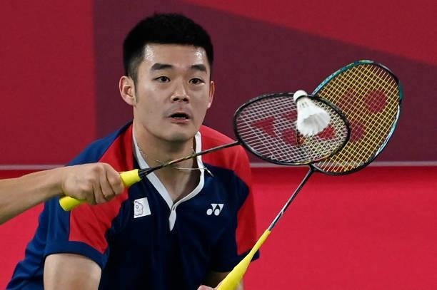 Taiwan's Wang Chi-lin looks on as Taiwan's Lee Yang hits a shot in their men's doubles badminton semi-final match against Indonesia's Mohammad Ahsan...