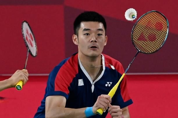 Taiwan's Wang Chi-lin prepares to hit a shot next to Taiwan's Lee Yang in their men's doubles badminton semi-final match against Indonesia's Mohammad...