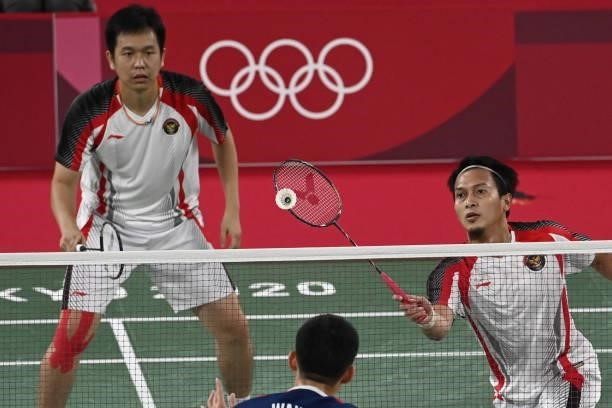 Indonesia's Mohammad Ahsan hits a shot next to Indonesia's Hendra Setiawan in their men's doubles badminton semi-final match against Taiwan's Wang...