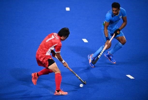 Japan's Kazuma Murata dribbles the ball during the men's pool A match of the Tokyo 2020 Olympic Games field hockey competition against India, at the...