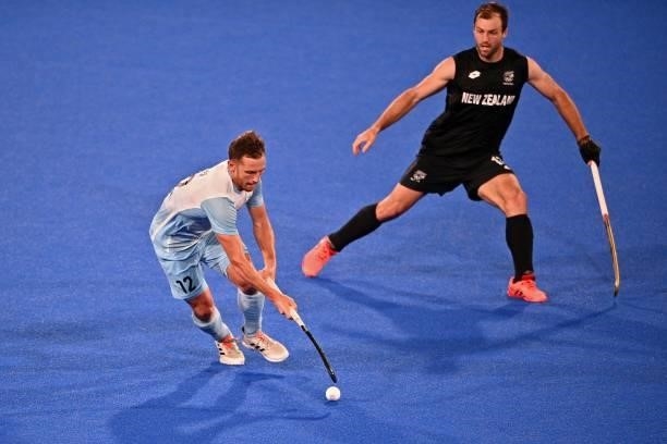 Argentina's Lucas Martin Vila dribbles the ball next to New Zealand's Nic Woods during their men's pool A match of the Tokyo 2020 Olympic Games field...