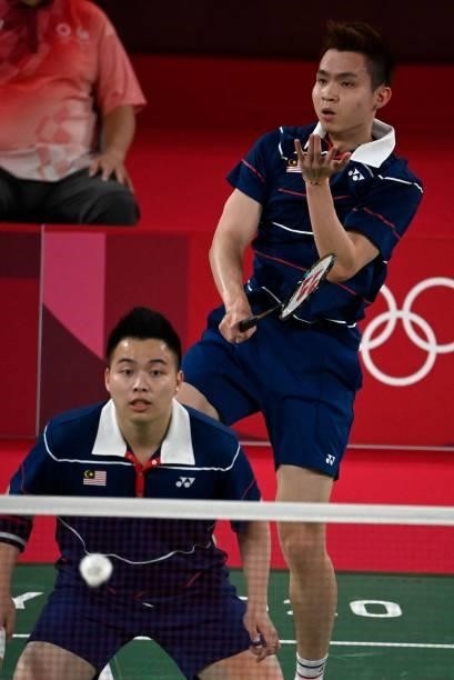 Malaysia's Soh Wooi Yik hits a shot next to Malaysia's Aaron Chia in their men's doubles badminton semi-final match against China's Liu Yuchen and...