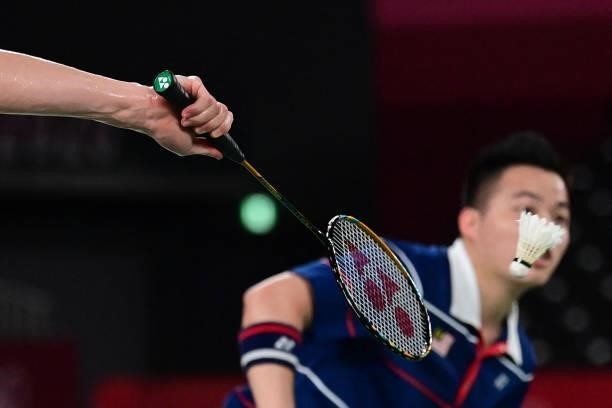 Malaysia's Soh Wooi Yik hits a shot next to Malaysia's Aaron Chia in their men's doubles badminton semi-final match against China's Liu Yuchen and...