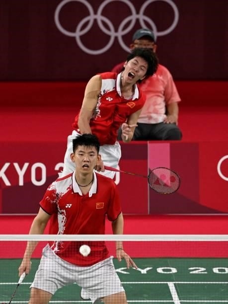 China's Li Junhui hits a shot next to China's Liu Yuchen in their men's doubles badminton semi-final match against Malaysia's Soh Wooi Yik and...