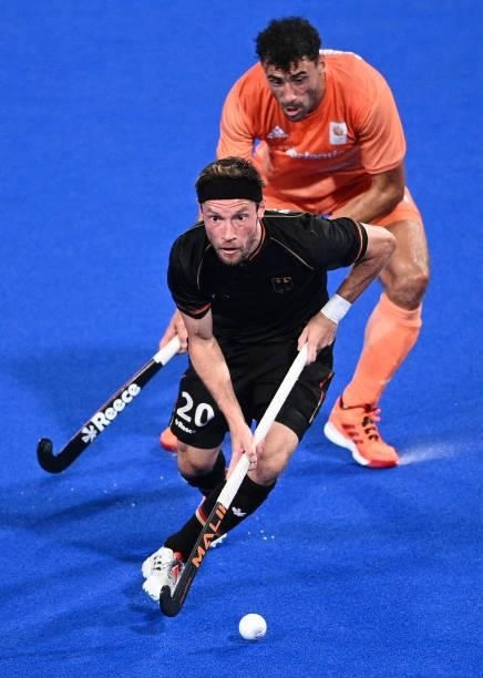 Germany's Martin Detlef Zwicker is challenged by Netherlands' Glenn Schuurman during their men's pool B match of the Tokyo 2020 Olympic Games field...
