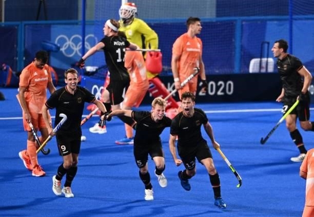Germany's Niklas Wellen , Linus Muller and Timm Alexander Herzbruch celebrate after the team scored a goal during the men's pool B match of the Tokyo...