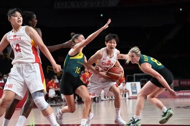 China's Yang Liwei holds the ball as Australia's Liz Cambage and Katie Ebzery try to block in the women's preliminary round group C basketball match...