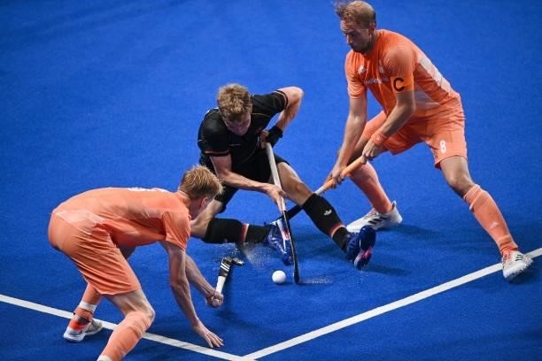 Germany's Niklas Bosserhoff vies for the ball with Netherlands' Joep Paul Eric De Mol and Billy Bakker during their men's pool B match of the Tokyo...