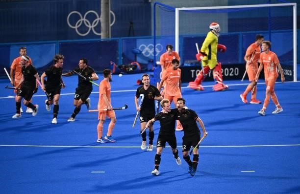 Germany's Linus Muller and Timm Alexander Herzbruch celebrate after the team scored a goal during the men's pool B match of the Tokyo 2020 Olympic...