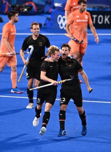 Germany's Niklas Wellen , Linus Muller and Timm Alexander Herzbruch celebrate after the team scored a goal against Netherlands during the men's pool...