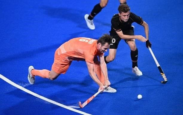 Netherlands' Mirco Pruijser and Belgium's Cedric Daniel Andre Charlier vie for the ball during their men's pool B match of the Tokyo 2020 Olympic...