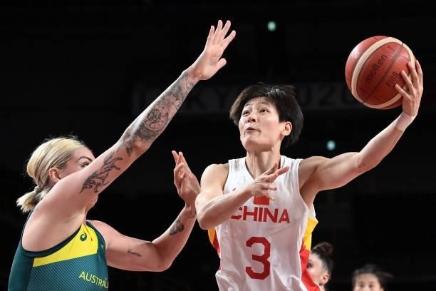 China's Yang Liwei goes to the basket past Australia's Cayla George in the women's preliminary round group C basketball match between China and...