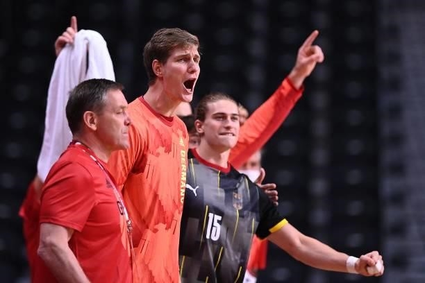Germany's centre back Juri Knorr and teammates react on the sideline during the men's preliminary round group A handball match between Germany and...