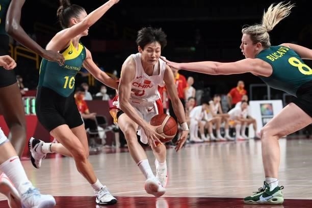 China's Yang Liwei holds the ball as Australia's Liz Cambage and Katie Ebzery try to block in the women's preliminary round group C basketball match...