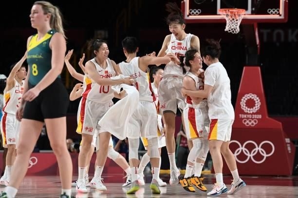 Australia's Liz Cambage walks past China's players celebrating their win in the women's preliminary round group C basketball match between China and...