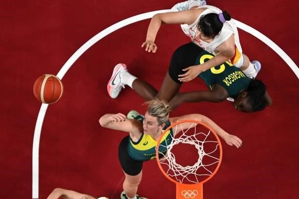 Australia's Liz Cambage jumps for the ball as her teammate Ezi Magbegor falls on the court in the women's preliminary round group C basketball match...