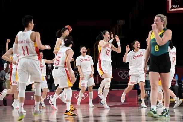 Australia's Liz Cambage walks past China's players celebrating their win in the women's preliminary round group C basketball match between China and...