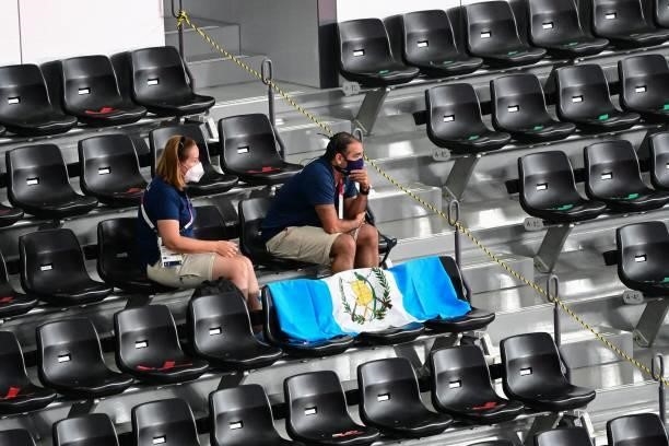 Members of the Guatemalan delegation watch Guatemala's Kevin Cordon play South Korea's Heo Kwang-hee next to empty seats in the men's singles...
