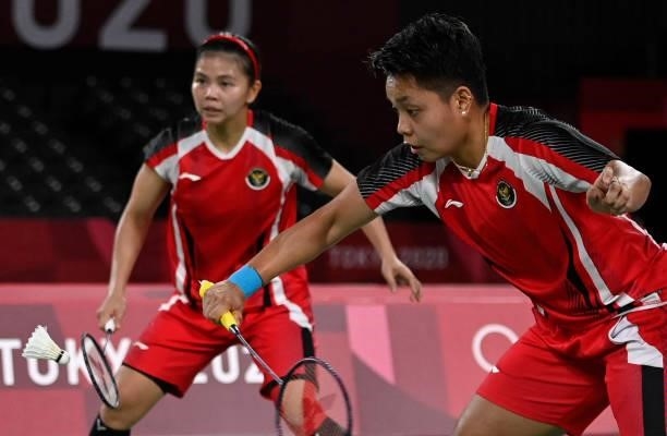 Indonesia's Apriyani Rahayu hits a shot next to Indonesia's Greysia Polii in their women's doubles badminton semi-final match against South Korea's...