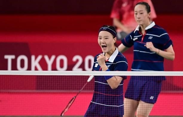 South Korea's Lee So-hee and South Korea's Shin Seung-chan react after a point in their women's doubles badminton semi-final match against...