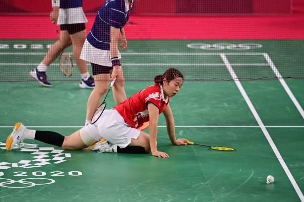 China's Jia Yifan reacts after falling during a rally with China's Chen Qingchen in their women's doubles badminton semi-final match against South...