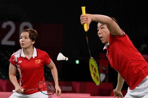 China's Jia Yifan hits a shot next to China's Chen Qingchen in their women's doubles badminton semi-final match against South Korea's Kong Hee-yong...