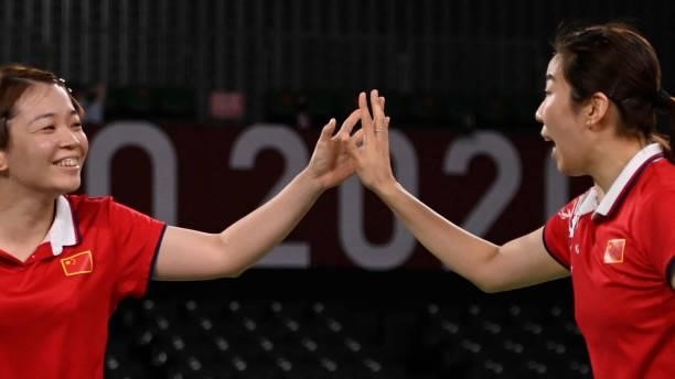 China's Chen Qingchen and China's Jia Yifan react after a point in their women's doubles badminton semi-final match against South Korea's Kong...