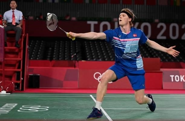 Denmark's Anders Antonsen hits a shot to Indonesia's Anthony Sinisuka Ginting in their men's singles badminton quarter final match during the Tokyo...