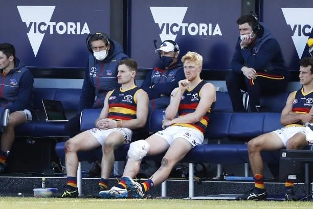 Elliott Himmelberg of the Crows is seen sitting on the bench with ice on his knee during the 2021 AFL Round 20 match between the Western Bulldogs and...