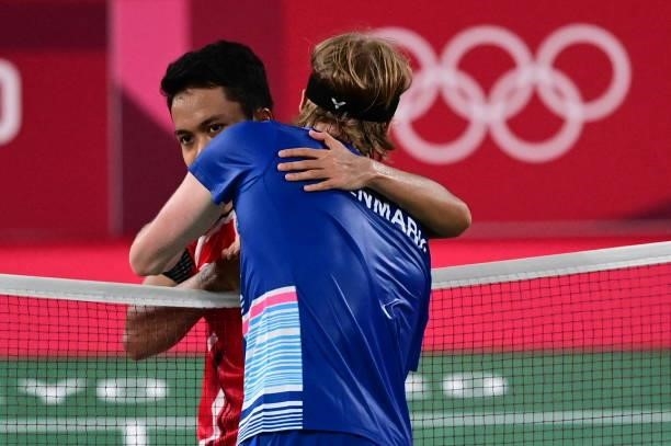 Indonesia's Anthony Sinisuka Ginting hugs Denmark's Anders Antonsen after winning their men's singles badminton quarter final match during the Tokyo...