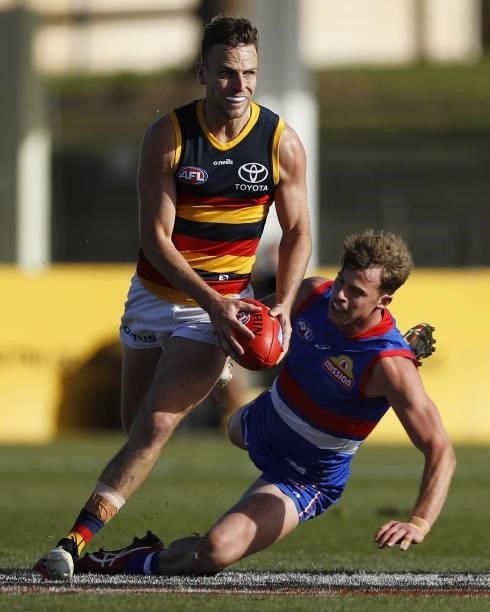 Brodie Smith of the Crows in action ahead of Mitch Hannan of the Bulldogs during the 2021 AFL Round 20 match between the Western Bulldogs and the...