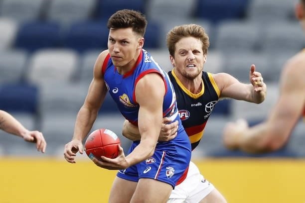 Anthony Scott of the Bulldogs is tackled by Rory Sloane of the Crows during the 2021 AFL Round 20 match between the Western Bulldogs and the Adelaide...