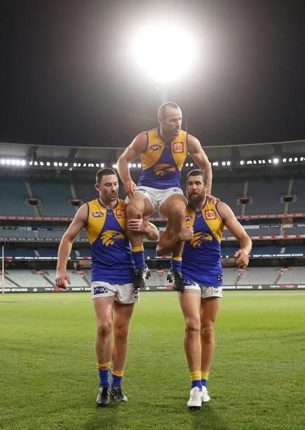 Shannon Hurn of the Eagles I chaired from the field after his 300th match by teammates Jeremy McGovern and Josh J. Kennedy during the 2021 AFL Round...