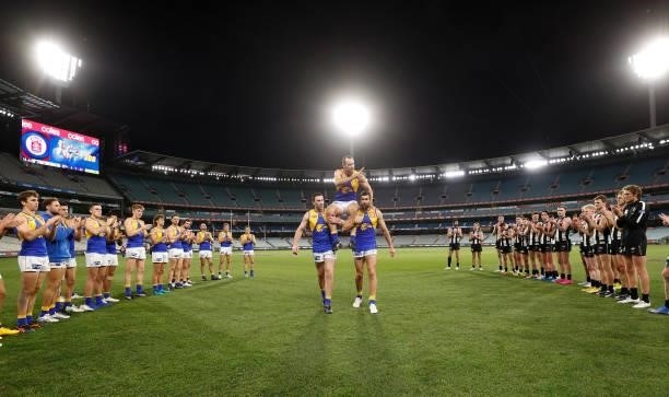 Shannon Hurn of the Eagles I chaired from the field after his 300th match by teammates Jeremy McGovern and Josh J. Kennedy during the 2021 AFL Round...