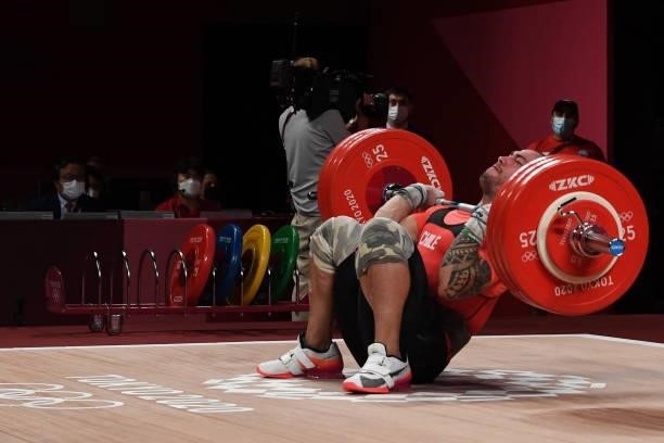 Chile's Arley Mendez Perez falls as he competes in the men's 81kg weightlifting competition during the Tokyo 2020 Olympic Games at the Tokyo...