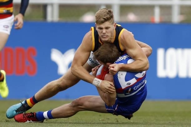 Mitch Hannan of the Bulldogs is tackled by Nick Murray of the Crows during the 2021 AFL Round 20 match between the Western Bulldogs and the Adelaide...