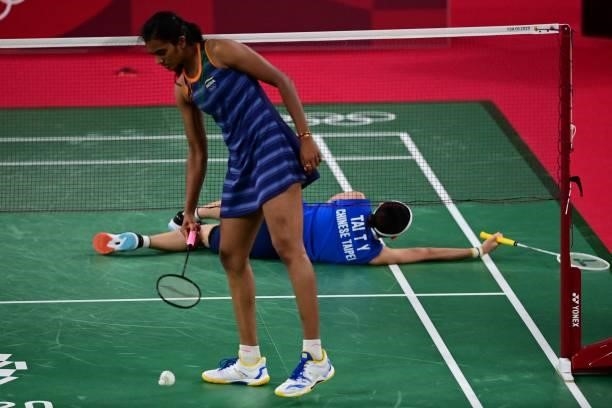 Taiwan's Tai Tzu-ying falls after a rally with India's P. V. Sindhu in their women's singles badminton semi-final match during the Tokyo 2020 Olympic...