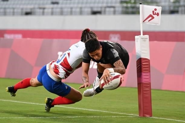 New Zealand's Gayle Broughton scores a try despite a tackle by France's Jade Ulutule in the women's final rugby sevens match between New Zealand and...