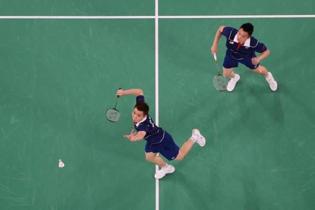 Malaysia's Soh Wooi Yik hits a shot next to Malaysia's Aaron Chia in their men's doubles badminton bronze medal match against Indonesia's Mohammad...