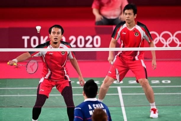 Indonesia's Mohammad Ahsan hits a shot next to Indonesia's Hendra Setiawan in their men's doubles badminton bronze medal match against Malaysia's...