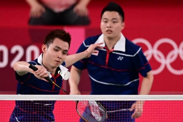 Malaysia's Soh Wooi Yik hits a shot next to Malaysia's Aaron Chia in their men's doubles badminton bronze medal match against Indonesia's Mohammad...