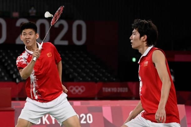 China's Liu Yuchen hits a shot next to China's Li Junhui in their men's doubles badminton final match against Taiwan's Wang Chi-lin and Taiwan's Lee...