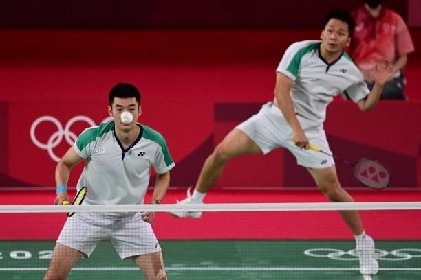 Taiwan's Lee Yang hits a shot next to Taiwan's Wang Chi-lin in their men's doubles badminton final match against China's Li Junhui and China's Liu...